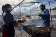 <p>A woman buys meat as a snack, on the street in Khayelitsha is one of the poorest areas of Cape Town. (Photograph by Silvia Landi) </p>