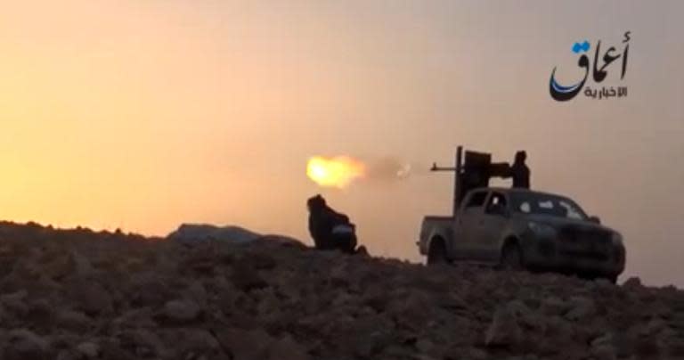 An image grab taken from a video uploaded on October 10, 2014, by Aamaq News Agency, a YouTube channel, allegedly shows Islamic State group fighters on the outskirts of Ain al-Arab in Syria