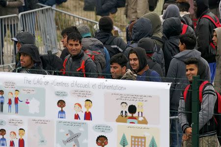 Migrants with their belongings queue at the start of their evacuation and transfer to reception centers (CAO) in France, and the dismantlement of the camp called the "Jungle" in Calais, France, October 24, 2016. REUTERS/Pascal Rossignol