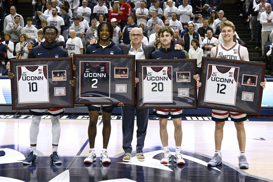 Seniors UConn guard Hassan Diarra (10), UConn guard Tristen Newton (2), UConn guard Andrew Hurley (20) and UConn guard Cam Spencer (12) are celebrated with UConn head coach Dan Hurley, center, before an NCAA college basketball game, Sunday, March 3, 2024, in Storrs, Conn. (AP Photo/Jessica Hill)