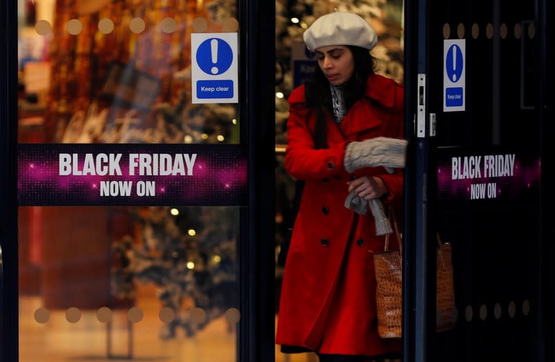 A woman walks past a sign advertising Black Friday offers at a House of Fraser store in Manchester, Britain