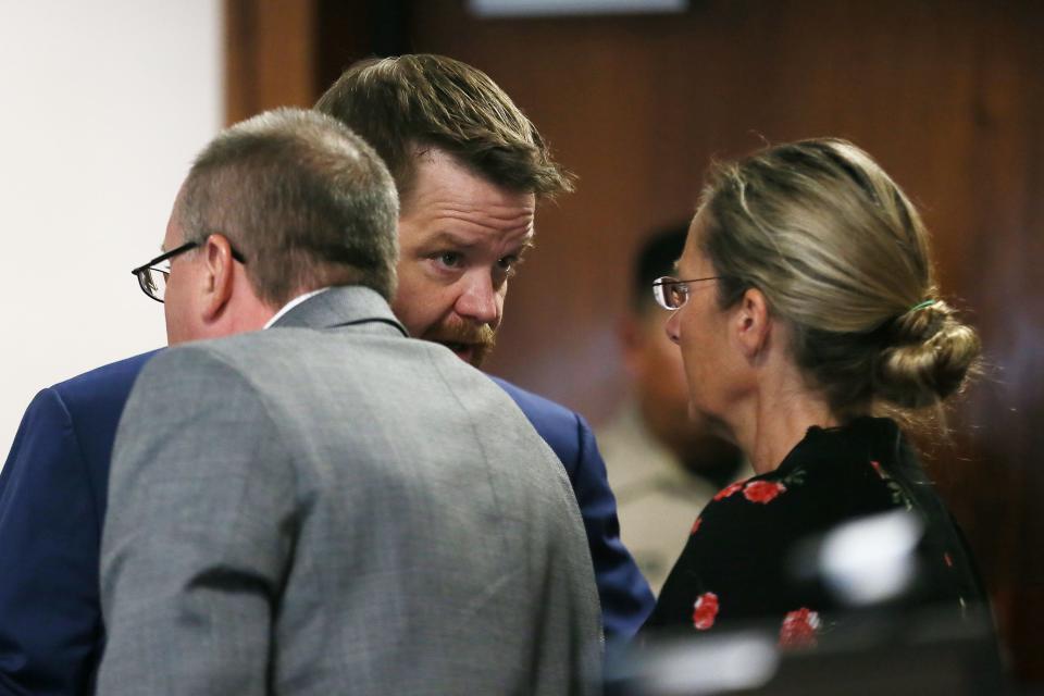 Lawyer Mark Bankston speaks with clients Neil Heslin and Scarlett Lewis, parents of Sandy Hook shooting victim Jesse Lewis, during the fourth day of Alex Jones' defamation award trial. Heslin and Lewis are seeking two awards of $150 million from Austin-based conspiracy theorist Jones.