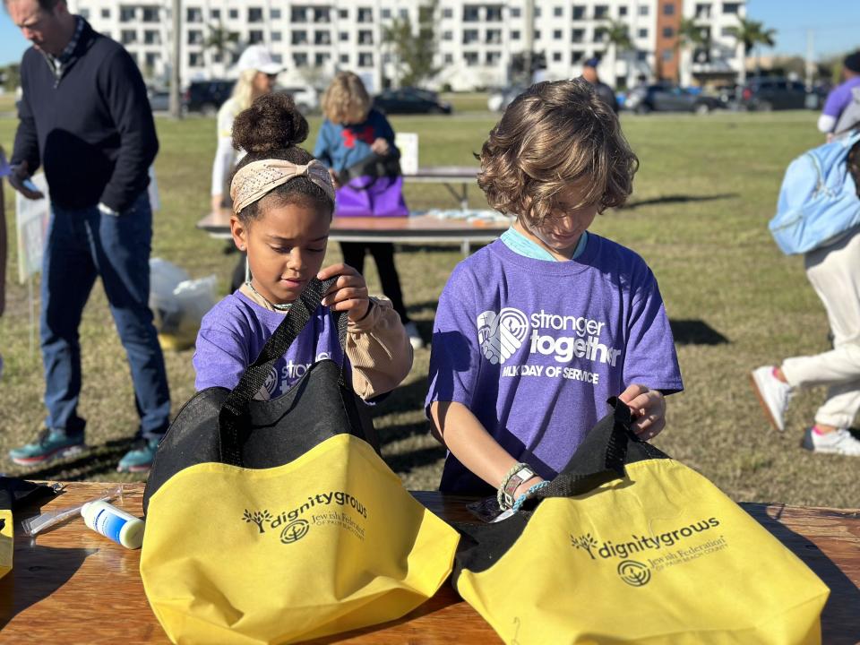 Volunteers help pack lunches and toiletry kits for people experiencing homelessness at Currie Park in West Palm Beach on Jan. 16, 2023. The toiletry kits included period products, shampoo, soap, a razor and shaving cream, a toothbrush and toothpaste and body wipes.