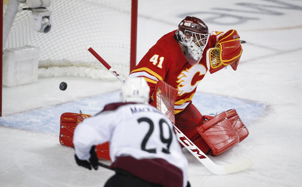 Colorado Avalanche center Nathan MacKinnon (29) scores on Calgary Flames goaltender Mike Smith (41) during overtime of an NHL hockey playoff game in Calgary, Alberta, Saturday, April 13, 2019. (Jeff McIntosh/The Canadian Press via AP)