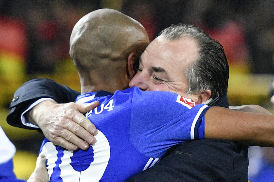FILE-In this Nov. 25, 2017 file photo Schalke chairman Clemens Toennies, right, embraces scorer Naldo after the Bundesliga soccer match between Borussia Dortmund and FC Schalke 04 in Dortmund, Germany. Schalke chairman Clemens Tönnies has resisted calls to resign and will instead step down for three months over comments he made last week that were widely condemned as racist. (AP Photo/Martin Meissner)