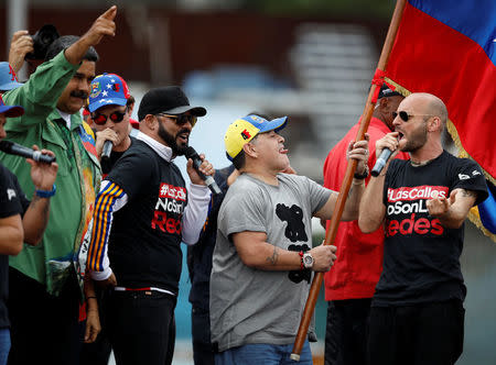 Venezuela's President Nicolas Maduro and former Argentinian soccer player Diego Armando Maradona greet supporters during a campaign rally in Caracas, Venezuela May 17, 2018. REUTERS/Carlos Garcia Rawlins