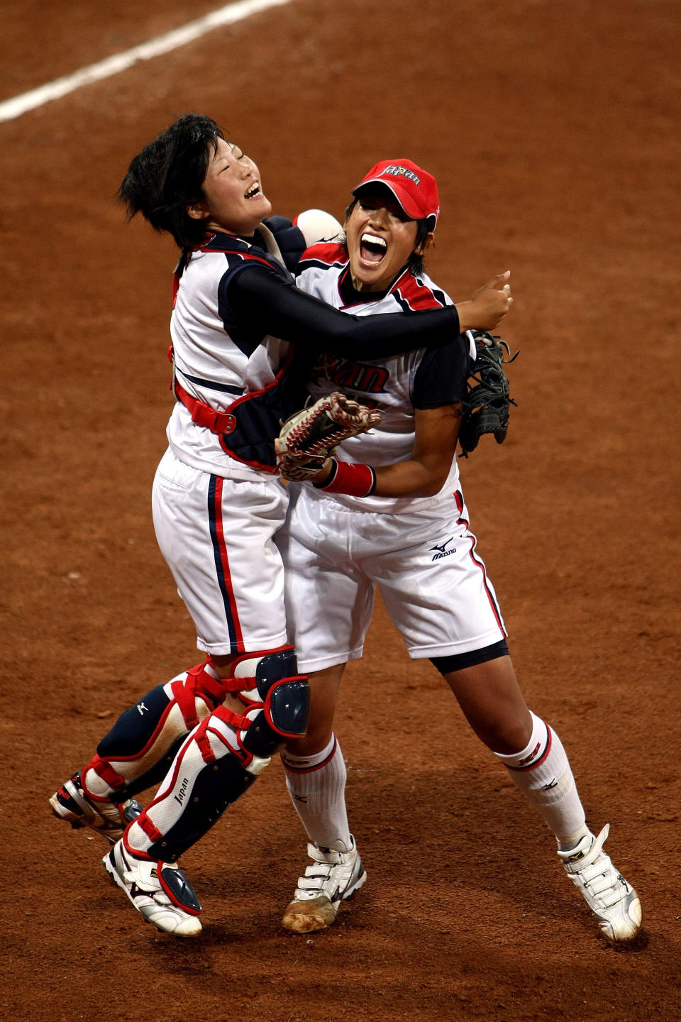 BEIJING - AUGUST 21: Catcher Yukiyo Mine #2 (L) and Yukiko Ueno #17 of Japan celebrate Japan's 3-1 win against the United States during the women's grand final gold medal softball game at the Fengtai Softball Field during Day 13 of the Beijing 2008 Olympic Games on August 21, 2008 in Beijing, China. (Photo by Jonathan Ferrey/Getty Images)