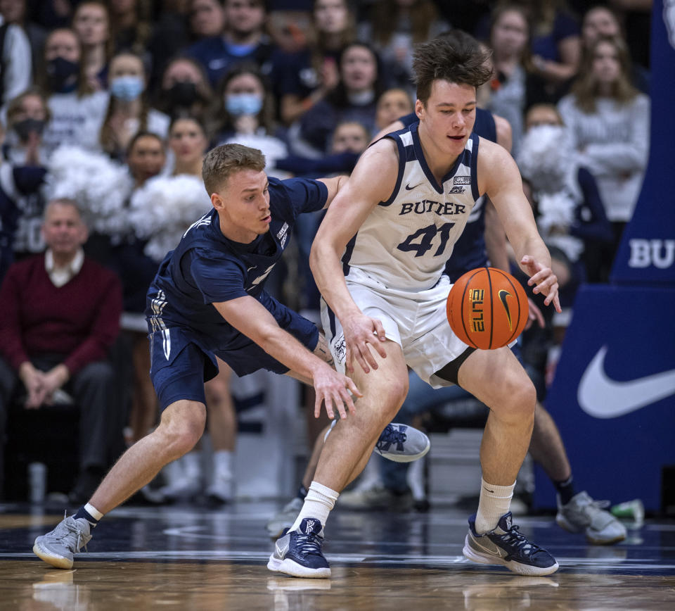 Xavier guard Adam Kunkel, left, knocks the ball away from Butler guard Simas Lukosius (41) during the first half of an NCAA college basketball game Friday, Jan. 7, 2022, in Indianapolis. (AP Photo/Doug McSchooler)