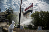 Workers disinfect the streets to prevent the spread of coronavirus in Qamishli, Syria, Tuesday, March 24, 2020. (AP Photo/Baderkhan Ahmad)