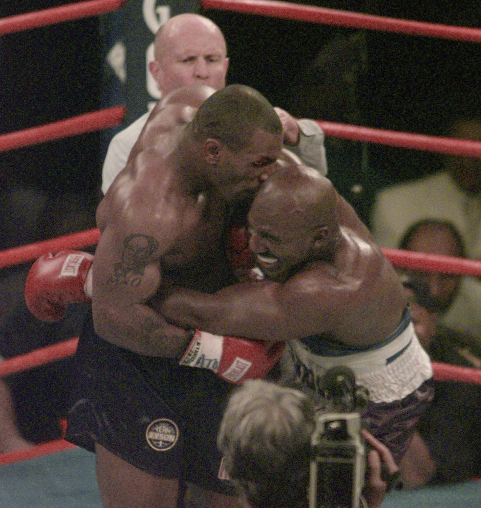 FILE -- Mike Tyson, left, bites into the ear of Evander Holyfield in the third round of their WBA heavyweight boxing bout in Las Vegas, June 28, 1997. Jack Smith, an AP photographer who captured unforgettable shots of the eruption of Mount St. Helens, the Exxon-Valdez oil spill, the Olympics and many other events during his 35-year career with the news organization, passed away on Jan. 4, 2023, at his home in La Mesa, Calif. He was 80. (AP Photo/Jack Smith, File)