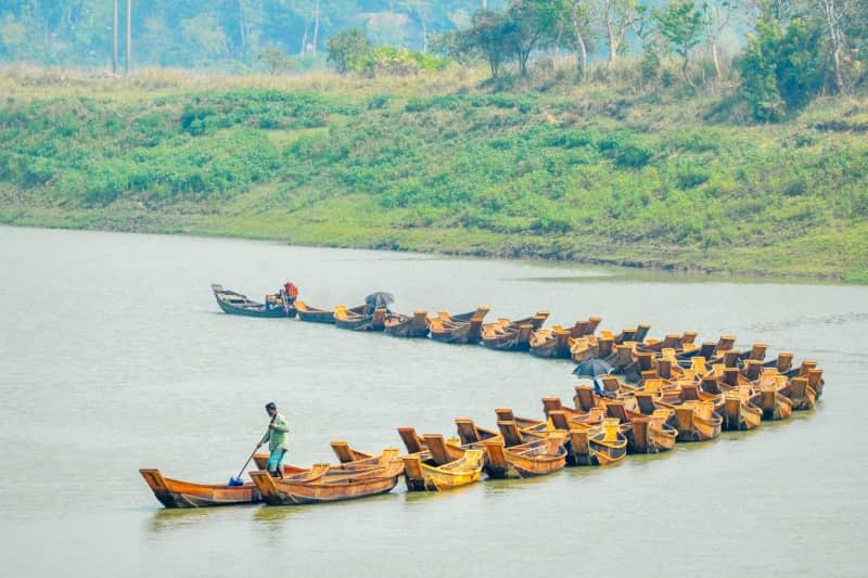Traders tie together about a hundred wooden 'barki' boats like a train of boats on the Chengerkhal River. Md Rafayat Haque Khan/ZUMA Press Wire/dpa
