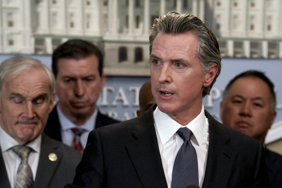 FILE - California Gov. Gavin Newsom, flanked by lawmakers, discusses the mass shooting in Texas, during a news conference in Sacramento, Calif., on May 25, 2022. California Democratic Gov. Gavin Newsom is headed to Washington this week, providing him with a national stage to continue his outspoken defense of abortion rights and gun control while lambasting Republican-led states that he sees as a threat to personal freedom and public safety. (AP Photo/Rich Pedroncelli, File)