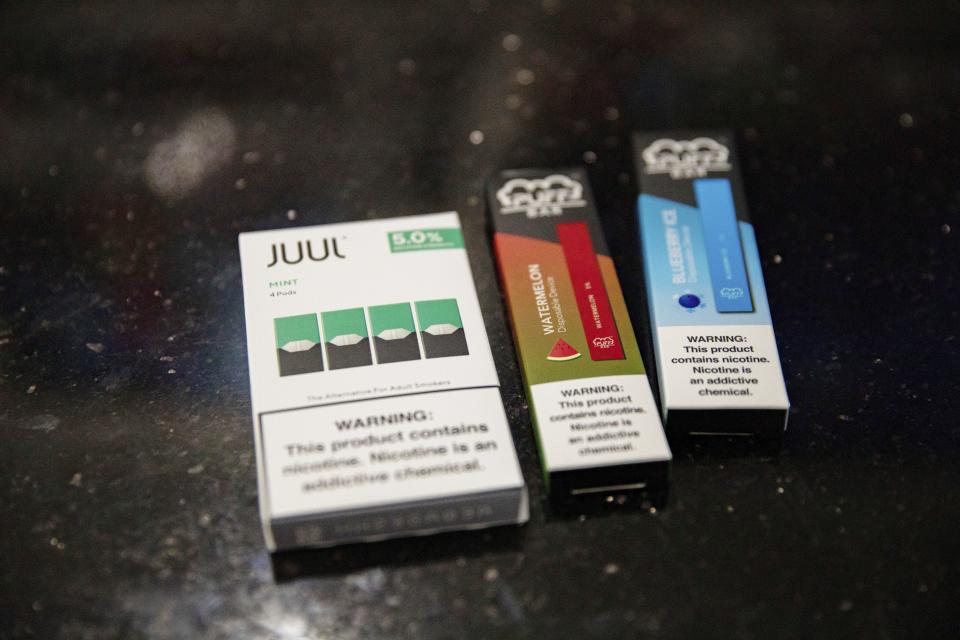 This Jan. 31, 2020 photo shows mint Juul pods next to Puff Bar flavored disposable vape devices at a store in the Brooklyn borough of New York. On Thursday, Feb. 6, 2020, the U.S. government began enforcing restrictions on flavored electronic cigarettes aimed at curbing underage vaping. But parents, researchers and students warn that some young people have already moved on to a newer kind of vape that isn't covered by the flavor ban - disposables. (AP Photo/Marshall Ritzel)