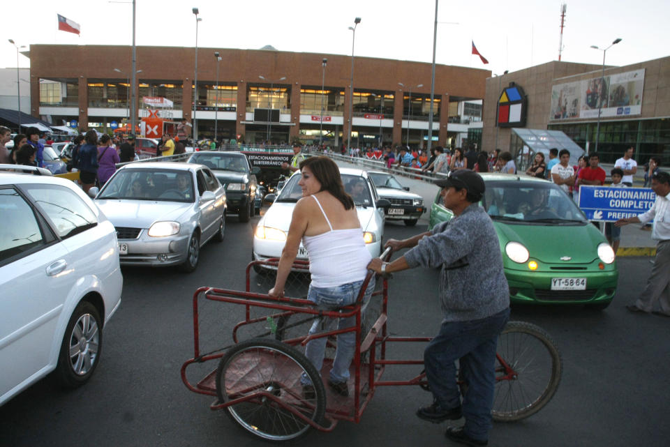 People gather outside a shopping mall after an earthquake was felt in Talca, Chile, Sunday, March 25, 2012. A magnitude-7.2 earthquake has struck just off the coast of central Chile, prompting an emergency evacuation order for people living near the ocean in case it spawns a tsunami. (AP Photo/Fabian Suazo)