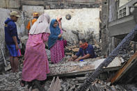 People inspect the ruins of their house in a neighborhood affected by a fuel depot fire in Jakarta, Indonesia, Saturday, March 4, 2023. A large fire broke out at the fuel storage depot in Indonesia's capital Friday, killing multiple people, injuring dozens of others and forcing the evacuation of thousands of nearby residents after spreading to their neighborhood, officials said. (AP Photo/Tatan Syuflana)