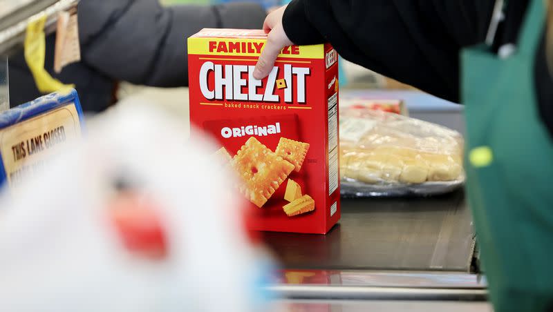 Employee Natasha Borgersen scans a box of Cheez-It crackers at Reams in Sandy on April 4, 2023.