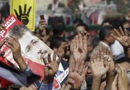 Supporters of ousted Egyptian president Mohamed Mursi hold his poster and a "Rabaa" sign outside the Egyptian High Court in Cairo November 4, 2013. Mursi struck a defiant tone on the first day of his trial on Monday, chanting 'Down with military rule', and calling himself the country's only 'legitimate' president. Mursi, an Islamist who was toppled by the army in July after mass protests against him, appeared angry and interrupted the session repeatedly, prompting a judge to adjourn the case. The "Rabaa" or "four" gesture is in reference to the police clearing of Rabaa al-Adawiya protest camp on August 14. REUTERS/Mohamed Abd El Ghany (EGYPT - Tags: POLITICS CIVIL UNREST CRIME LAW)