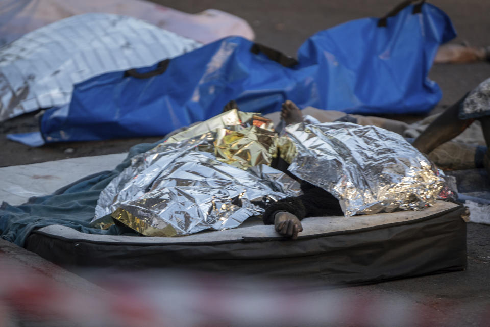 Cadáveres cubiertos con mantas térmicas, en el lugar donde se produjo un letal incendio en el centro de Johannesburgo, el 31 de agosto de 2023. (AP Foto)