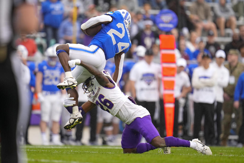 James Madison cornerback Devyn Coles (26) makes a hit on Air Force running back John Lee Eldridge III (24) during the first half of the Armed Forces Bowl NCAA college football game, Saturday, Dec. 23, 2023, in Fort Worth, Texas. (AP Photo/Julio Cortez)