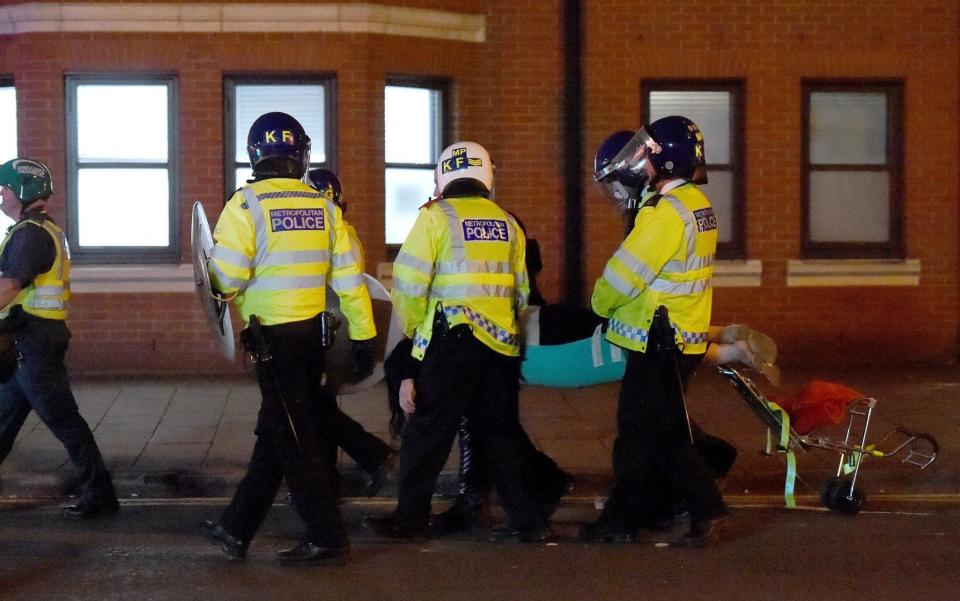 A person is carried away from the scene of the clashes with police in east London - Credit: Lauren Hurley/PA