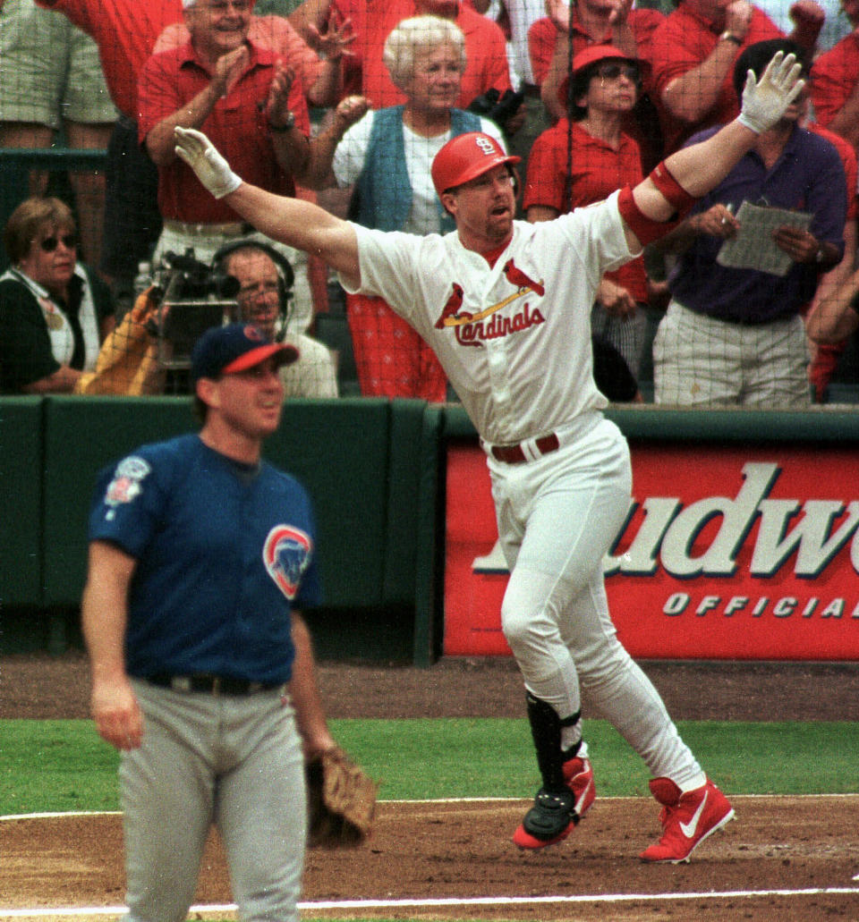 FILE - St. Louis Cardinals' Mark McGwire reacts as he hits his 61st home run of the season to tie Roger Maris' major league record as Chicago Cubs pitcher Mike Morgan, left, looks to the outfield during a baseball game on Sept. 7, 1998, at Busch Stadium in St. Louis. Former award-winning Associated Press photographer John Gaps III, who documented everything from war zones to the NCAA College World Series during his career, was found dead at his home Monday, Oct. 17, 2022, in Des Moines, Iowa, his family confirmed Tuesday. He was 63. (AP Photo/John Gaps III)