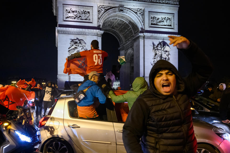 PARIS, FRANCE - DECEMBER 10: Moroccan fans celebrate in Champs Elysees after Moroccan football team beat Portugal in 2022 FIFA World Cup at Qatar in Paris, France on December 10, 2022. (Photo by Julien Mattia/Anadolu Agency via Getty Images)
