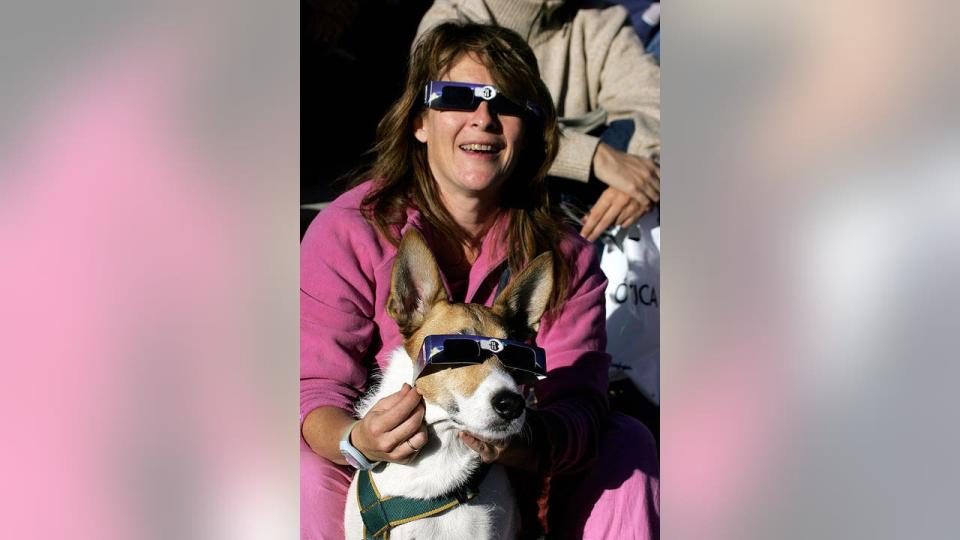 <div>MADRID, Spain: A dog and its owner watch the annular eclipse of the sun in Madrid, 03 October 2005. In an annular eclipse, the Moon moves between the Sun and Earth but, because of a tiny difference in distance due to celestial mechanics, does not completely cover the solar face as in a total eclipse. AFP PHOTO/PHILIPPE DESMAZES (Photo credit should read PHILIPPE DESMAZES/AFP via Getty Images)</div>