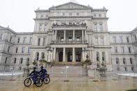 Michigan State Police officers patrol outside the state Capitol in Lansing, Mich., Friday, Jan. 15, 2021. With the FBI warning of potential violence at all state capitols Sunday, Jan. 17, the ornate halls of government and symbols of democracy looked more like heavily guarded U.S. embassies in war-torn countries. (AP Photo/Carlos Osorio)
