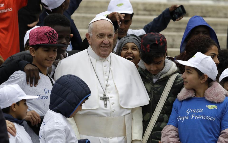 Pope Francis meets a group of migrants recently arrived from Libya, wearing shirts with writing reading "Thank you Pope Francis, at the end of his weekly general audience in St. Peter's Square, at the Vatican, Wednesday May 15, 2019. (AP Photo/Andrew Medichini)