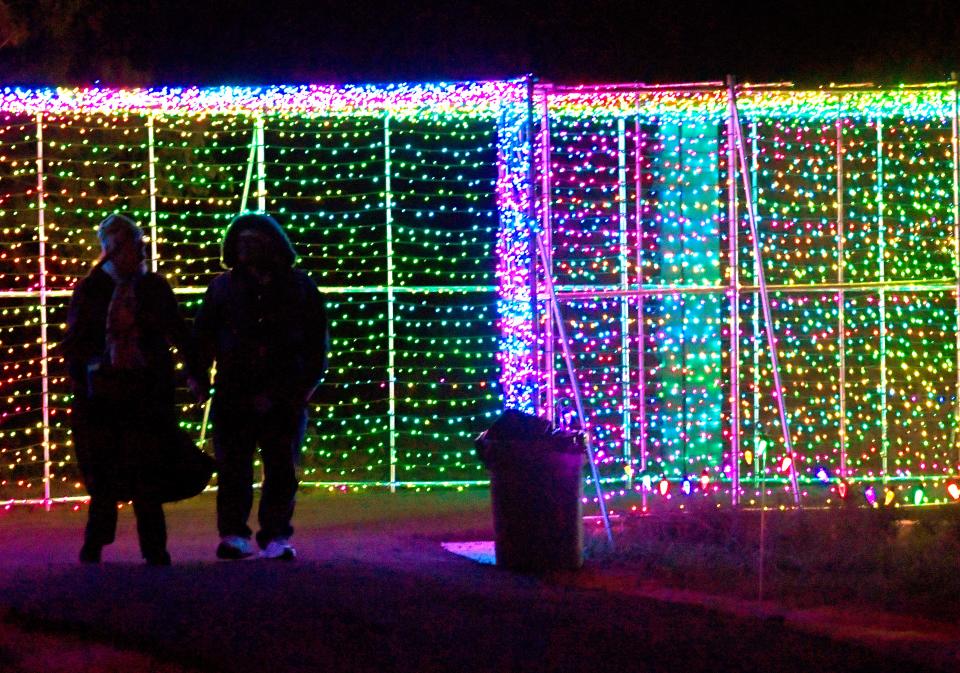 A couple is silhouetted as they stroll through one of three Tunnels of Love at United Way's Winter Lightfest.