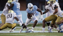 North Carolina's Javonte Williams (25) breaks away from Notre Dame's Shaun Crawford (20) in the first quarter of an NCAA college football game, Friday, Nov. 27, 2020, at Kenan Stadium in Chapel Hill, N.C. (Robert Willett/The News & Observer via AP)