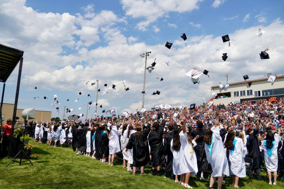 Members of the Sturgis High School class of 2022 throw their caps into the air, to celebrate their graduation.