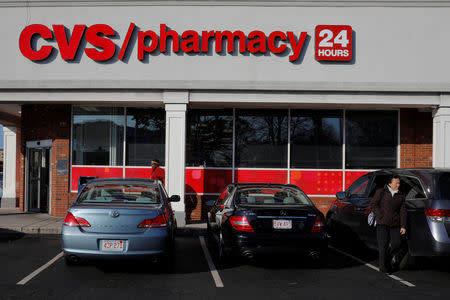 FILE PHOTO: Shoppers walk outside a CVS store and pharmacy in Medford, Massachusetts, U.S. December 4, 2017. REUTERS/Brian Snyder