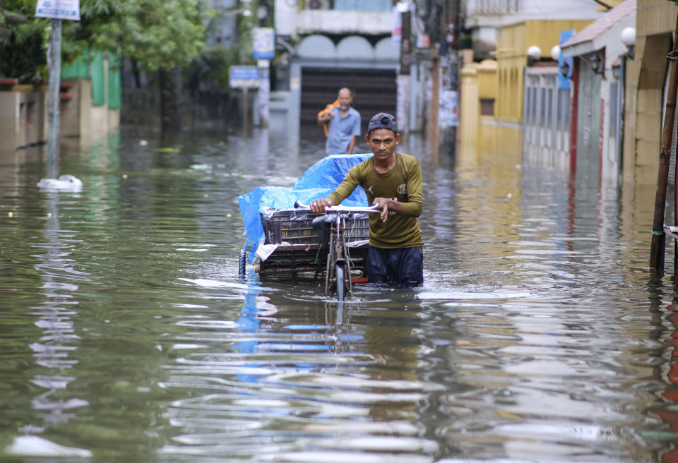 A man pushes his cart through flood waters in Sylhet, Bangladesh, Monday, June 20, 2022. Floods in Bangladesh continued to wreak havoc Monday with authorities struggling to ferry drinking water and dry food to flood shelters across the country’s vast northern and northeastern regions. (AP Photo/Mahmud Hossain Opu)