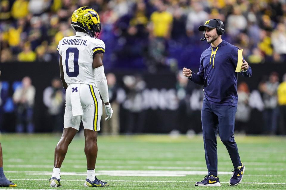 Michigan defensive coordinator Jesse Minter, right, talks to defensive back Mike Sainristil at a timeout during the second half of U-M's 26-0 win over Iowa in the Big Ten championship game in Indianapolis on Saturday, Dec. 2, 2023.