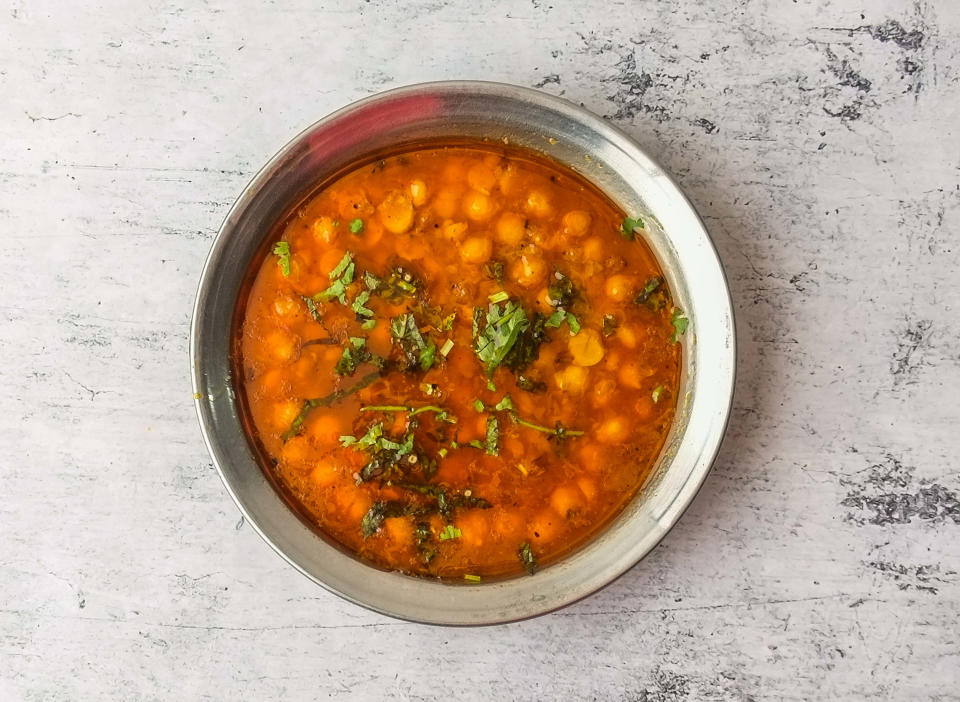 bright red orange stew with green garnish