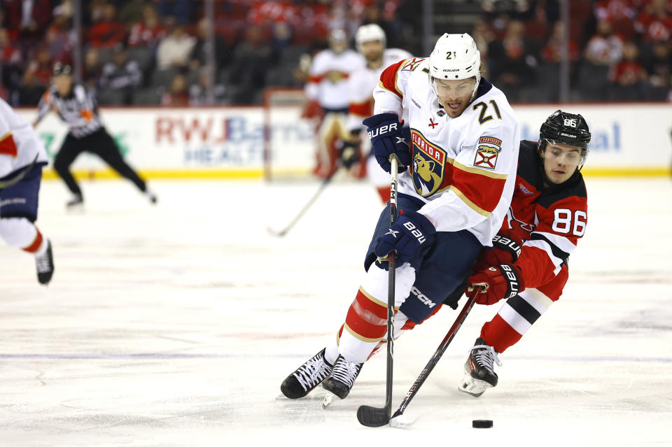 Florida Panthers center Nick Cousins (21) and New Jersey Devils center Jack Hughes (86) vie for the puck during the first period of an NHL hockey game, Tuesday, March 5, 2024, in Newark, N.J. (AP Photo/Noah K. Murray)