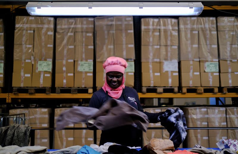 La trabajadora Emelia, ghanesa de 40 años, participante en un programa de la fundación "Formació i Treball" ("Formación y Trabajo"), cuyo objetivo es promover la contratación de personas desempleadas especialmente vulnerables, como los inmigrantes, separa y clasifica ropa usada para empaquetar en un almacén de Sant Esteve Sesrovires, a las afueras de Barcelona, Cataluña, España