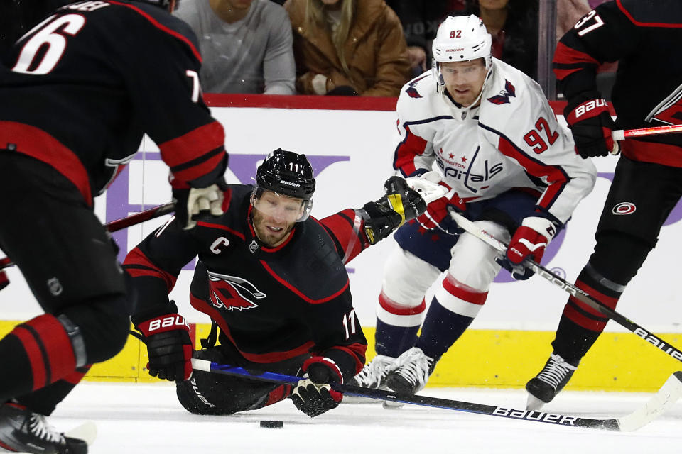 Carolina Hurricanes' Jordan Staal (11) falls to the ice after being tripped by Washington Capitals' Evgeny Kuznetsov (92) during the first period of an NHL hockey game in Raleigh, N.C., Sunday, Nov. 28, 2021. (AP Photo/Karl B DeBlaker)