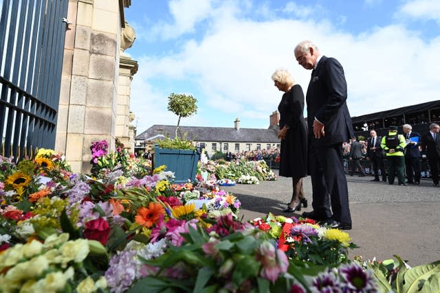 Charles and Camilla look at floral tributes at Hillsborough Castle