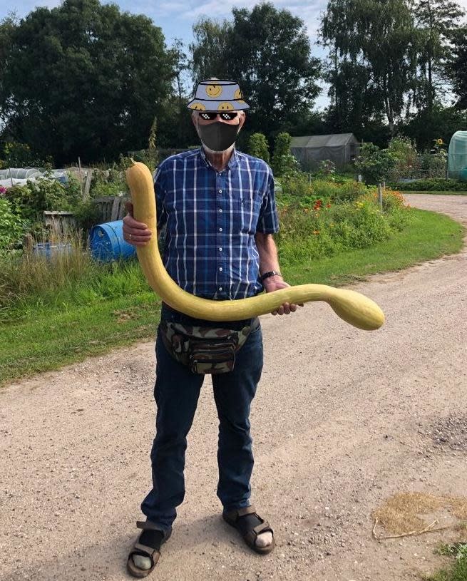 a man holding a long zucchini