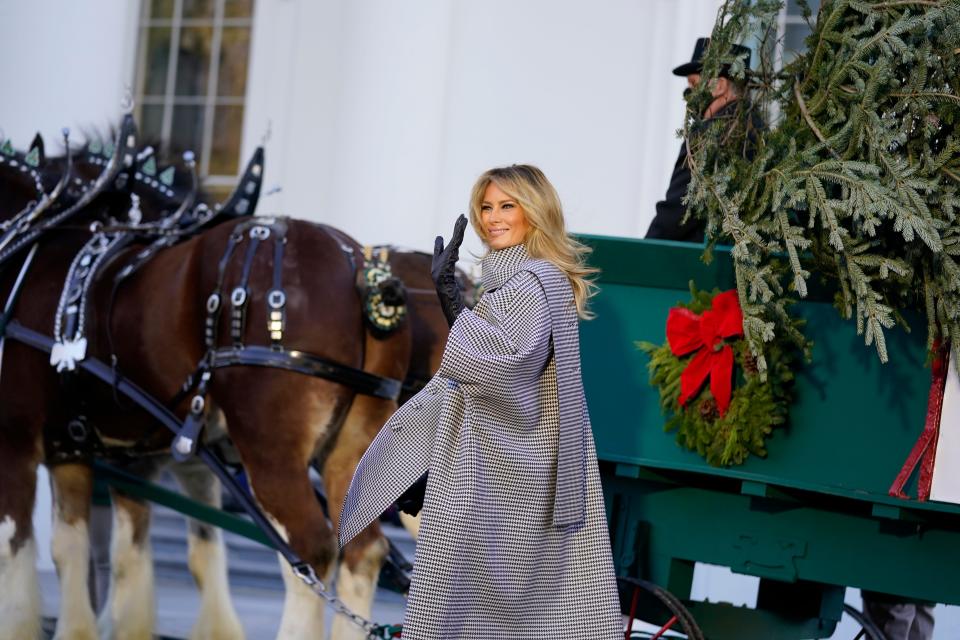 First lady Melania Trump waves as she stands next to the 2020 Official White House Christmas tree on Nov. 23, 2020.