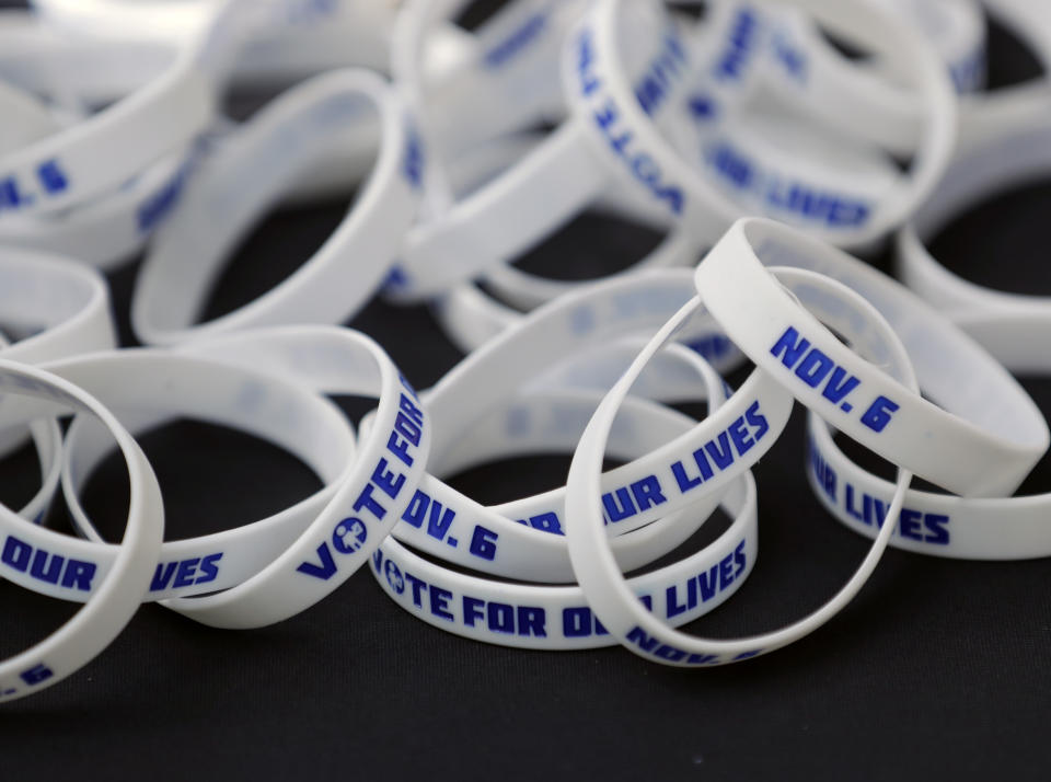 In this Wednesday, Oct. 31, 2018 photo, wristbands to encourage students to vote are seen on a table at a voting information booth during a Vote for Our Lives event at the University of Central Florida in Orlando, Fla. Nine months after 17 classmates and teachers were gunned down at their Florida school, Parkland students are finally facing the moment they’ve been leading up to with marches, school walkouts and voter-registration events throughout the country: their first Election Day. (AP Photo/John Raoux)