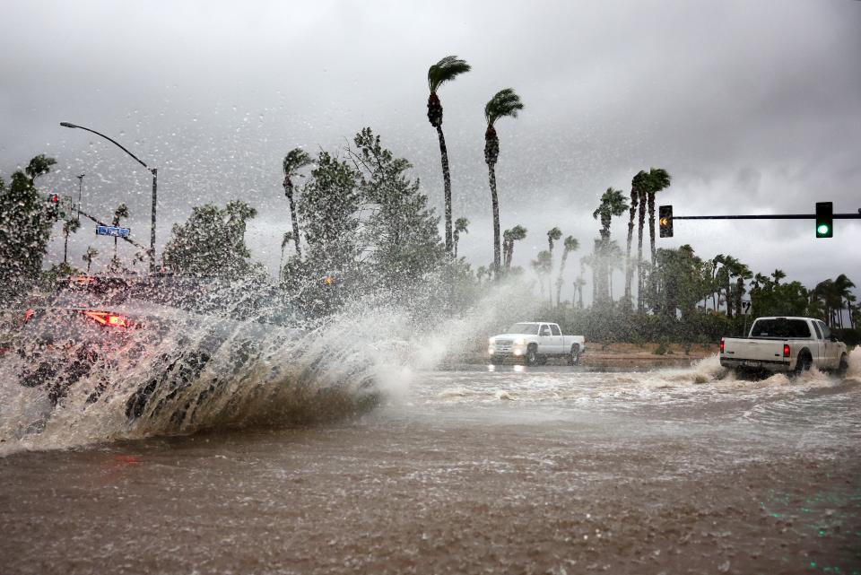 Vehicles drive through a flooded street as Tropical Storm Hilary moves through the area on August 20, 2023 in Cathedral City, California. Southern California is under a first-ever tropical storm warning as Hilary impacts parts of California, Arizona and Nevada.