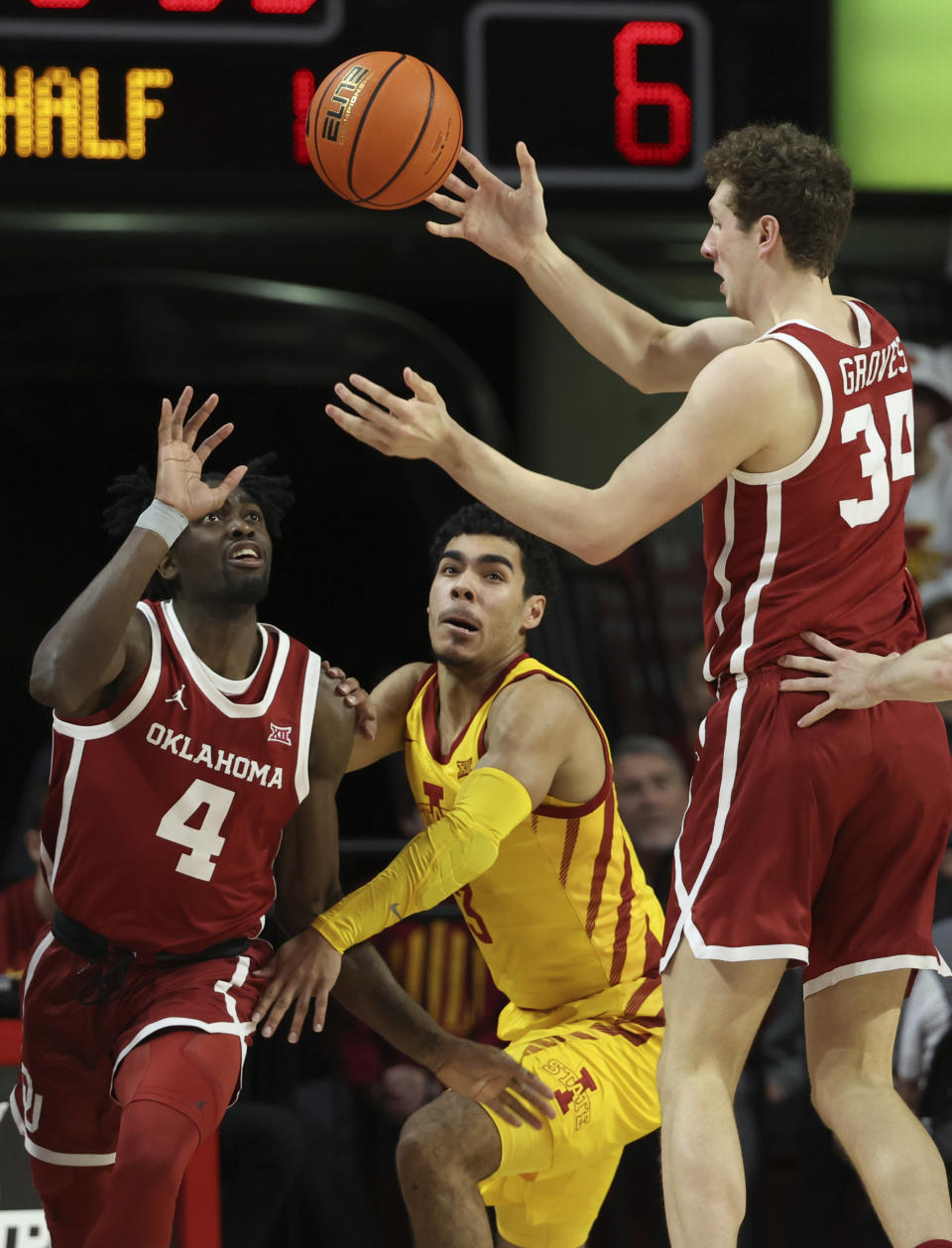 Oklahoma forward Jacob Groves (34) passes the ball to guard Joe Bamisile (4) as Iowa State guard Tamin Lipsey (3) tries to steal the ball during the first half of an NCAA college basketball game, Saturday, Feb. 25, 2023, in Ames, Iowa. (AP Photo/Justin Hayworth)