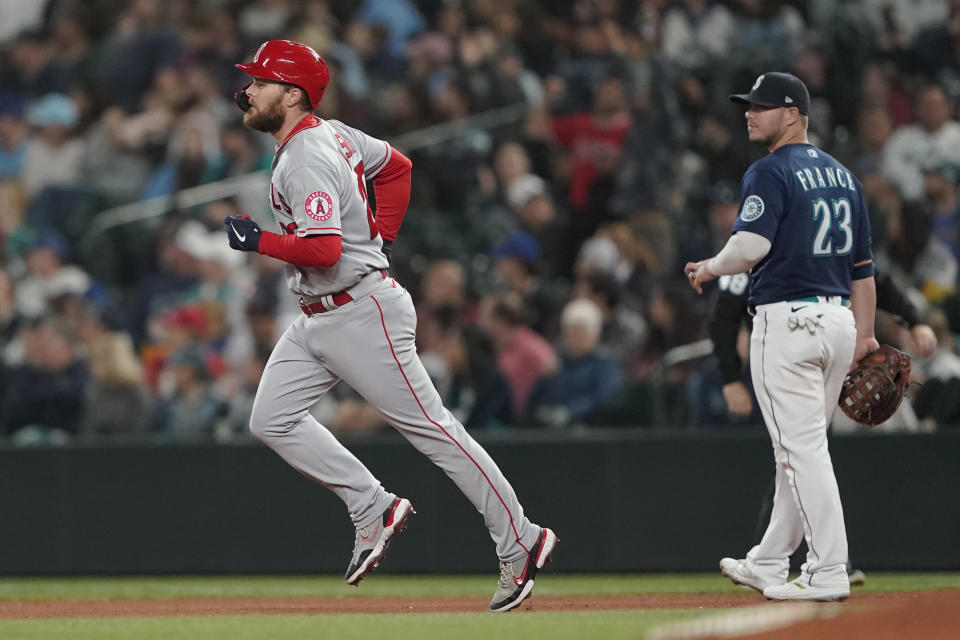 Los Angeles Angels' Jared Walsh, left, runs the bases past Seattle Mariners first baseman Ty France after he hit a two-run home run during the seventh inning of the second baseball game of a doubleheader Saturday, June 18, 2022, in Seattle. (AP Photo/Ted S. Warren)