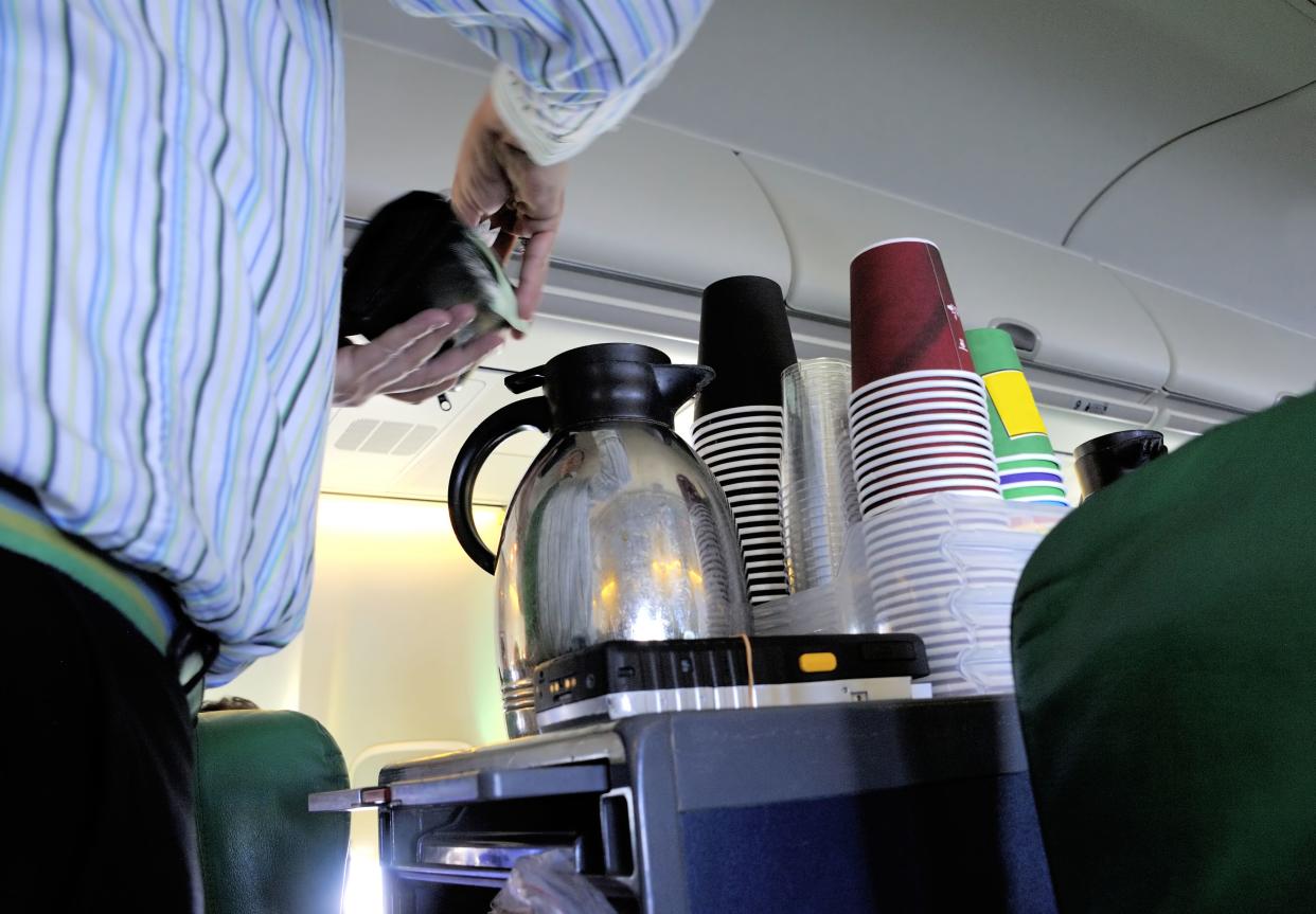 Steward pouring coffee in the cabin of an airplane