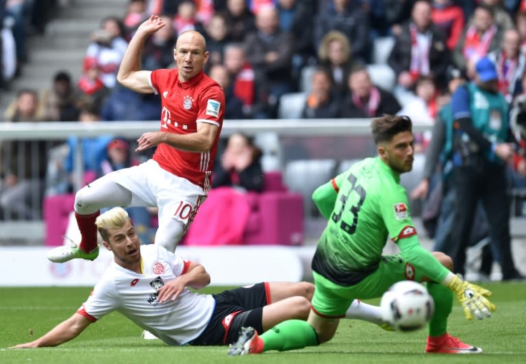 Bayern Munich's Arjen Robben (2ndL) scores the first goal for Munich against Mainz's goalkeeper Jannik Huth (R) during their German First division Bundesliga football match in Munich, Germany, on April 22, 2017
