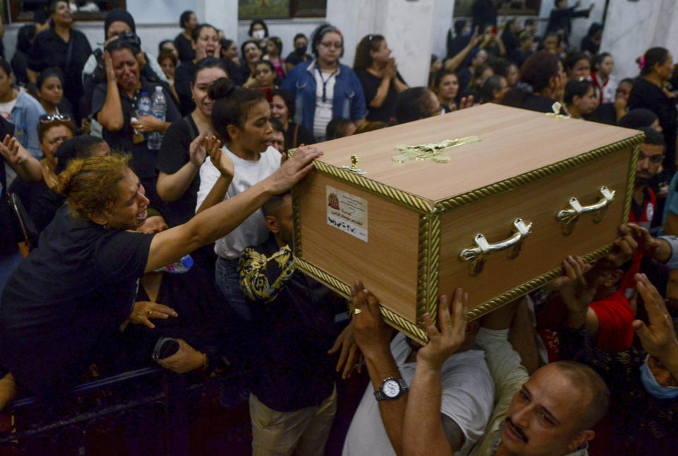 Mourners attend a memorial service for victims of a fire at a church in Greater Cairo that killed dozens on Sunday, Aug. 14, 2022. The blaze ignited at the Abu Sefein church in the densely populated neighborhood of Imbaba while a service was underway, according to the church. (AP Photo/Tarek Wajeh)