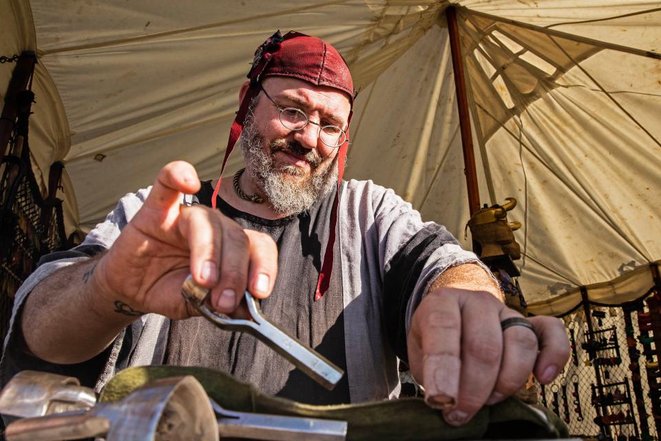Michael 'Scooter' Madzek, head goblin of Goblin Worx Leather Company LLC, works on a a leather piece on Day 1 of the second Delaware Renaissance Faire at Firebase Lloyd in Townsend, Saturday, Oct. 28, 2023.